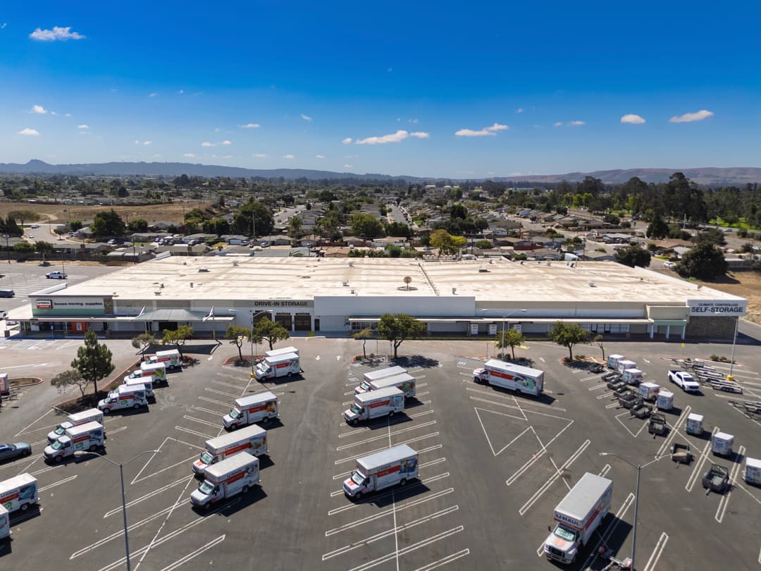 Aerial view of a self-storage facility with moving trucks parked in the foreground.