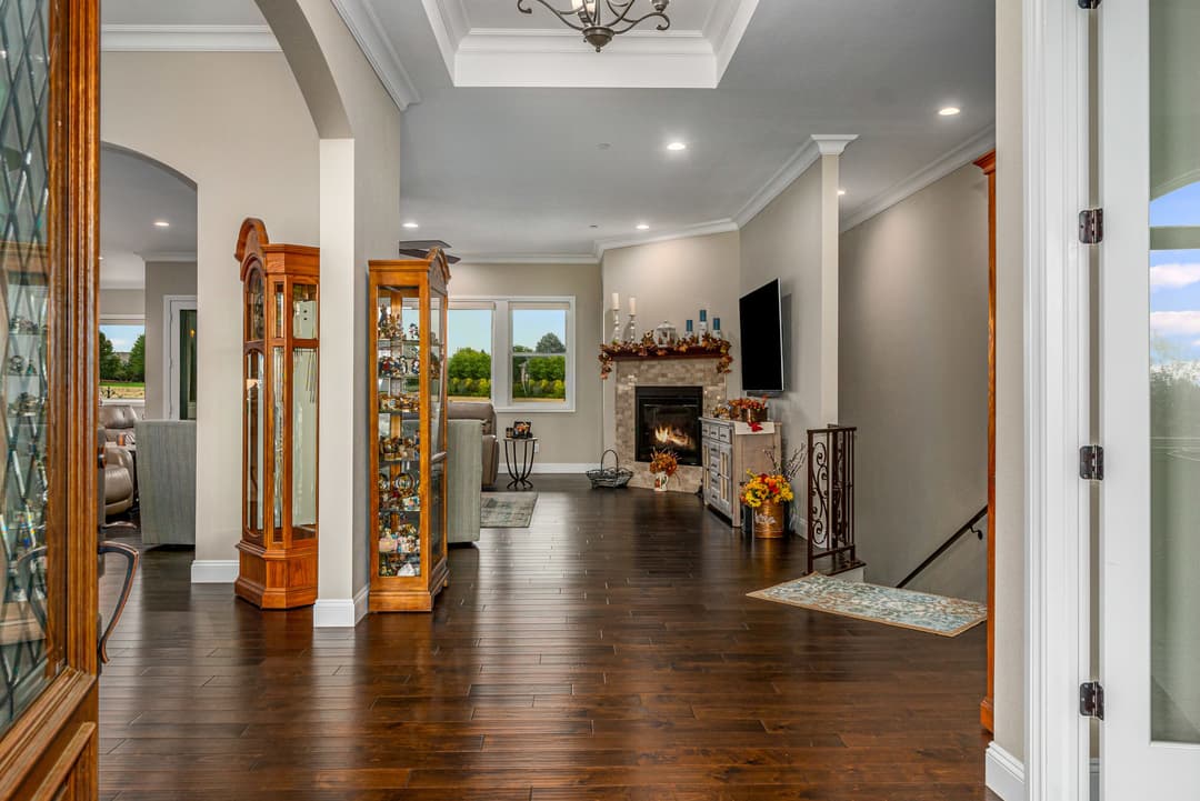 Spacious home interior with hardwood floors, fireplace, and elegant decor showcasing natural light.