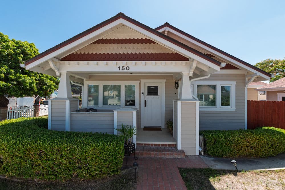 Charming craftsman-style home with a welcoming porch and lush greenery at 150.