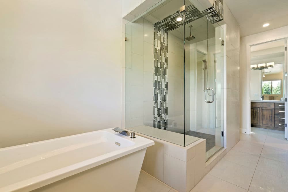 Modern bathroom featuring a glass shower, freestanding tub, and stylish tile accents.
